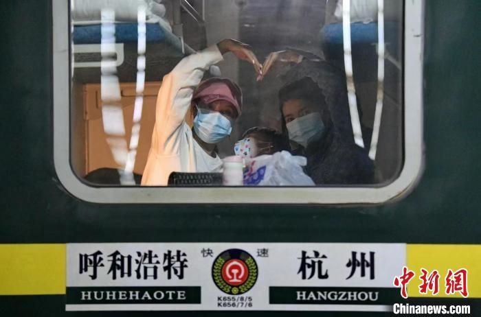 圖為登上轉(zhuǎn)運(yùn)火車的游客向額濟(jì)納比心?！⊥趵?攝