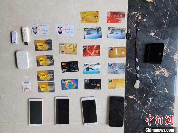 資料圖為果洛藏族自治州公安民警查扣的作案手機(jī)和涉案銀行卡?！‖斍呖h公安局供圖