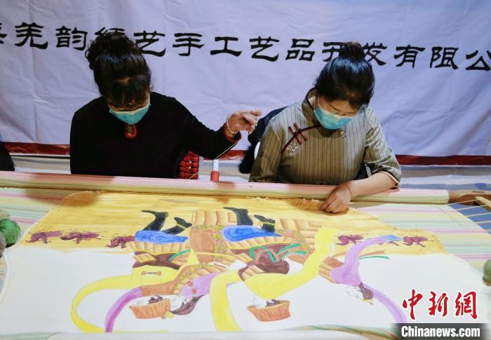 圖為皮繡藝人在市集上“秀”指尖技藝?！●R銘言 攝