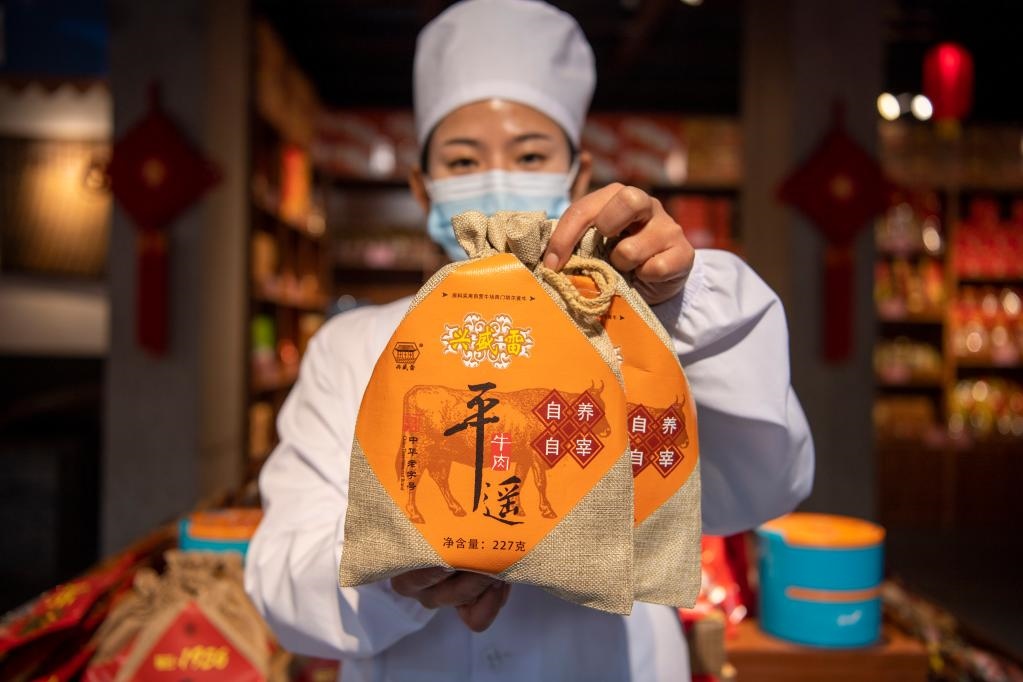 1月27日，在平遙古城南大街的一家平遙牛肉店內(nèi)，工作人員展示一款牛肉產(chǎn)品。新華社記者 楊晨光 攝