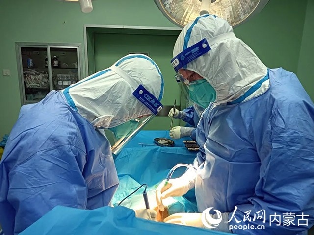 醫(yī)護(hù)人員正在為新冠肺炎合并腸梗阻腸穿孔的尿毒癥患者實(shí)施急診手術(shù)。呼和浩特市第一醫(yī)院供圖