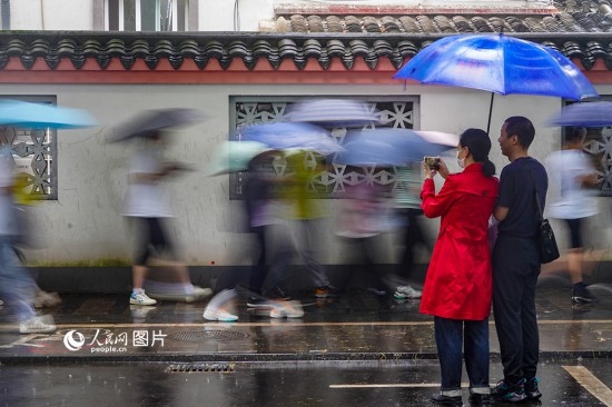 6月7日，在浙江省2023年普通高校招生考試鎮(zhèn)海中學(xué)考點，家長冒雨目送子女進(jìn)入考場。人民網(wǎng) 章勇濤攝