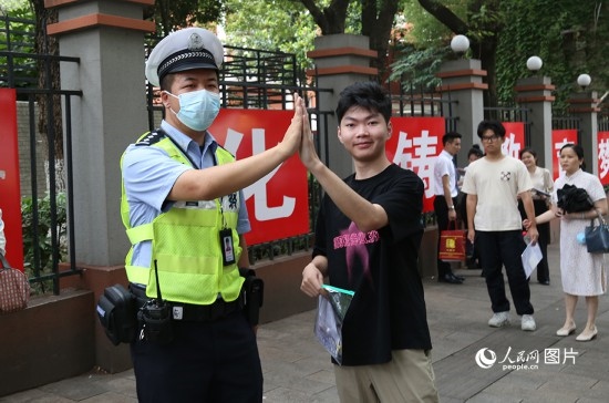 6月7日8時許，武漢中學(xué)考點門口，交警在維護(hù)秩序，并祝考生金榜題名。人民網(wǎng)記者 肖璐欣攝