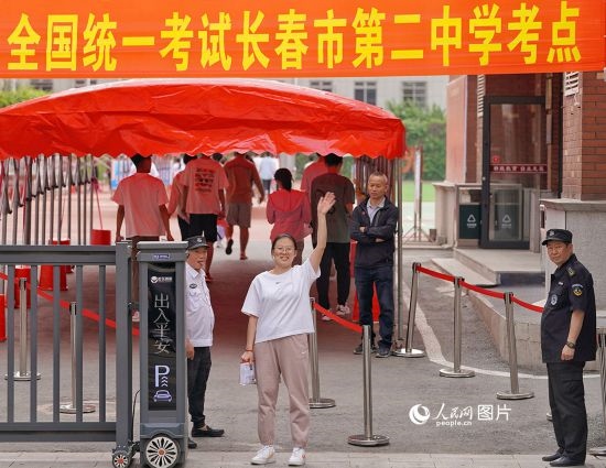 6月7日，在長春市第二中學(xué)考點，一名考生信心滿滿進(jìn)入考場，并與家長揮手致意。人民網(wǎng)記者 李洋攝