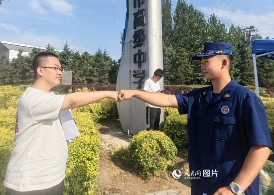 6月7日，遼寧營口老邊區(qū)消防救援大隊的消防員為高考學(xué)子加油助威。人民網(wǎng)記者 尹柏寒?dāng)z