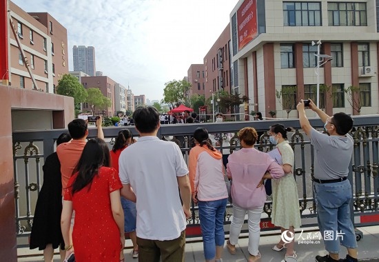 6月7日，武漢市第三中學(xué)考點，考生進(jìn)場后，家長在柵欄外用手機拍攝自己的孩子。人民網(wǎng)記者 郭婷婷攝