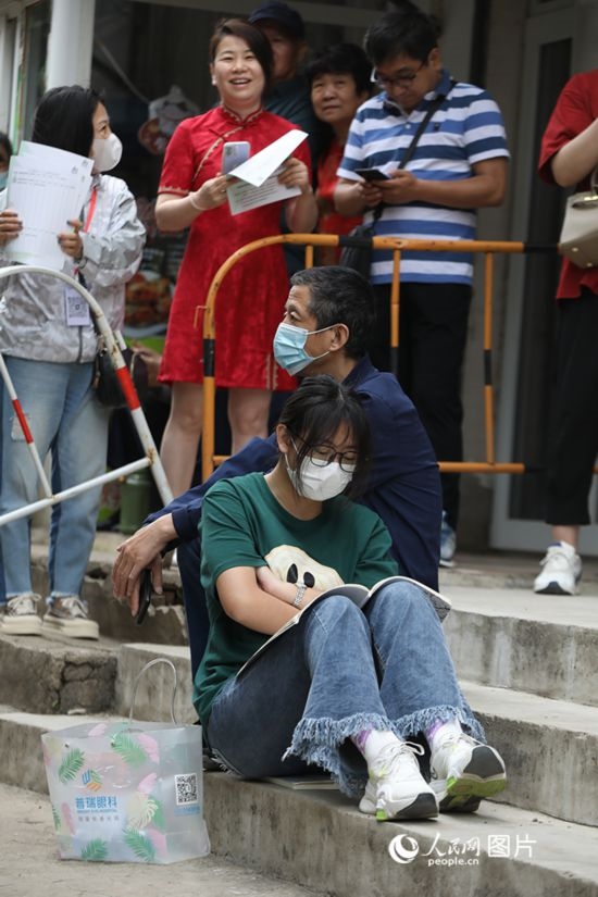 6月7日，沈陽市第一中學(xué)，學(xué)子靠在父親身邊做最后的沖刺。人民網(wǎng) 周頌雪攝