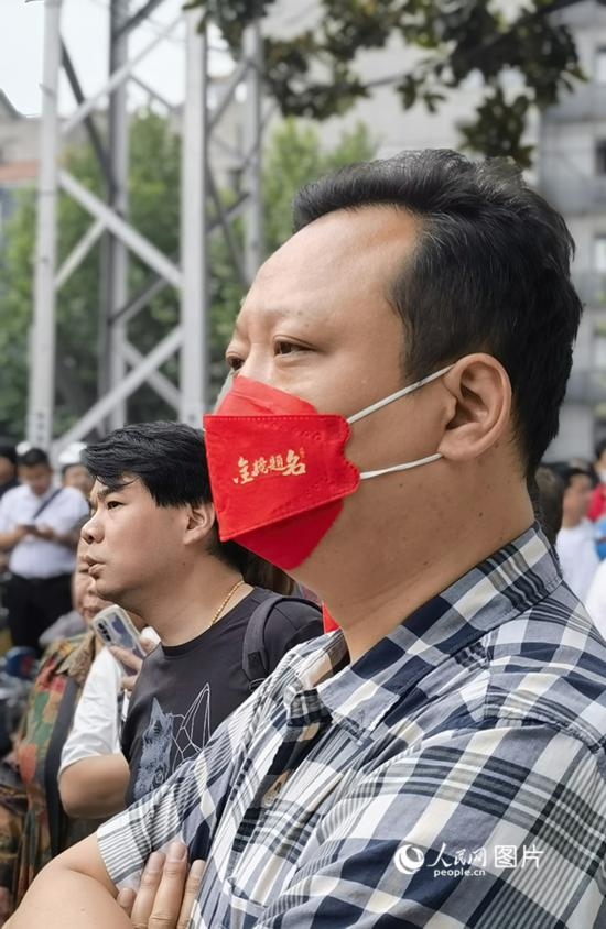 6月7日早，在武漢市第二十六中學(xué)考點外，送考家長戴著印有“金榜題名”的口罩。人民網(wǎng) 周雯攝