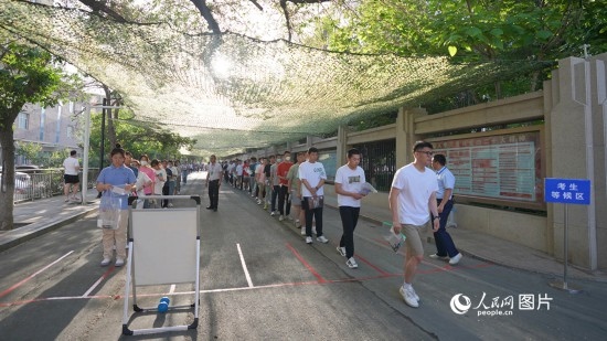 6月7日，烏魯木齊市第七十中學(xué)門口，考生們有序進(jìn)入考場。人民網(wǎng) 李欣洋攝