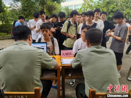 專武干部在發(fā)放兵役登記證。韋碩 攝