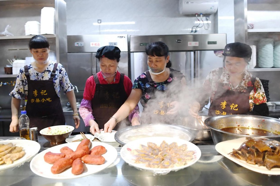 福建三明市沙縣區(qū)一家小吃店工作人員在為客人準(zhǔn)備特色小吃。 新華社記者 林善傳 攝