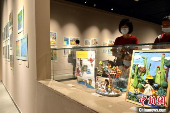 圖為家長帶著孩子參觀展覽。呂明 攝