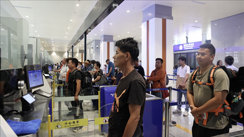 6月13日，乘坐中老鐵路國際旅客列車的旅客在磨憨邊檢大廳排隊(duì)候檢。李揚(yáng) 攝