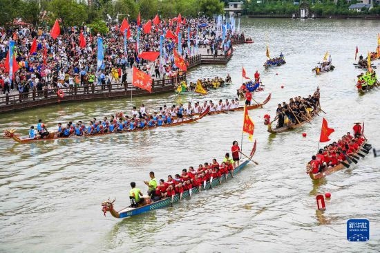 6月23日，在貴州省黔東南苗族侗族自治州施秉縣舉行的獨(dú)木龍舟節(jié)上，獨(dú)木龍舟進(jìn)行水上巡游。