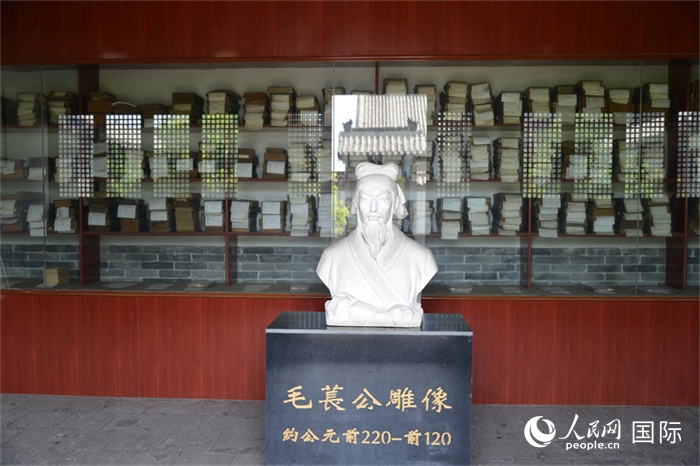 河間詩(shī)經(jīng)齋毛萇雕像。雕像后書櫥中陳列的是歷代各版本《詩(shī)經(jīng)》及譯本。 人民網(wǎng) 趙昭攝