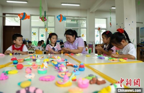 在肥西縣山南鎮(zhèn)中心幼兒園，孩子們?cè)诶蠋煹闹笇?dǎo)下做彩色泥塑。陳家樂(lè) 攝
