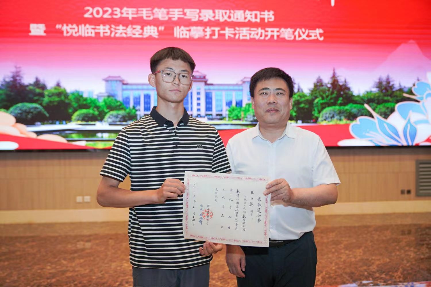 陜西師范大學(xué)黨委書記李忠軍為2023級新生代表張占彪同學(xué)發(fā)放錄取通知書。校方供圖