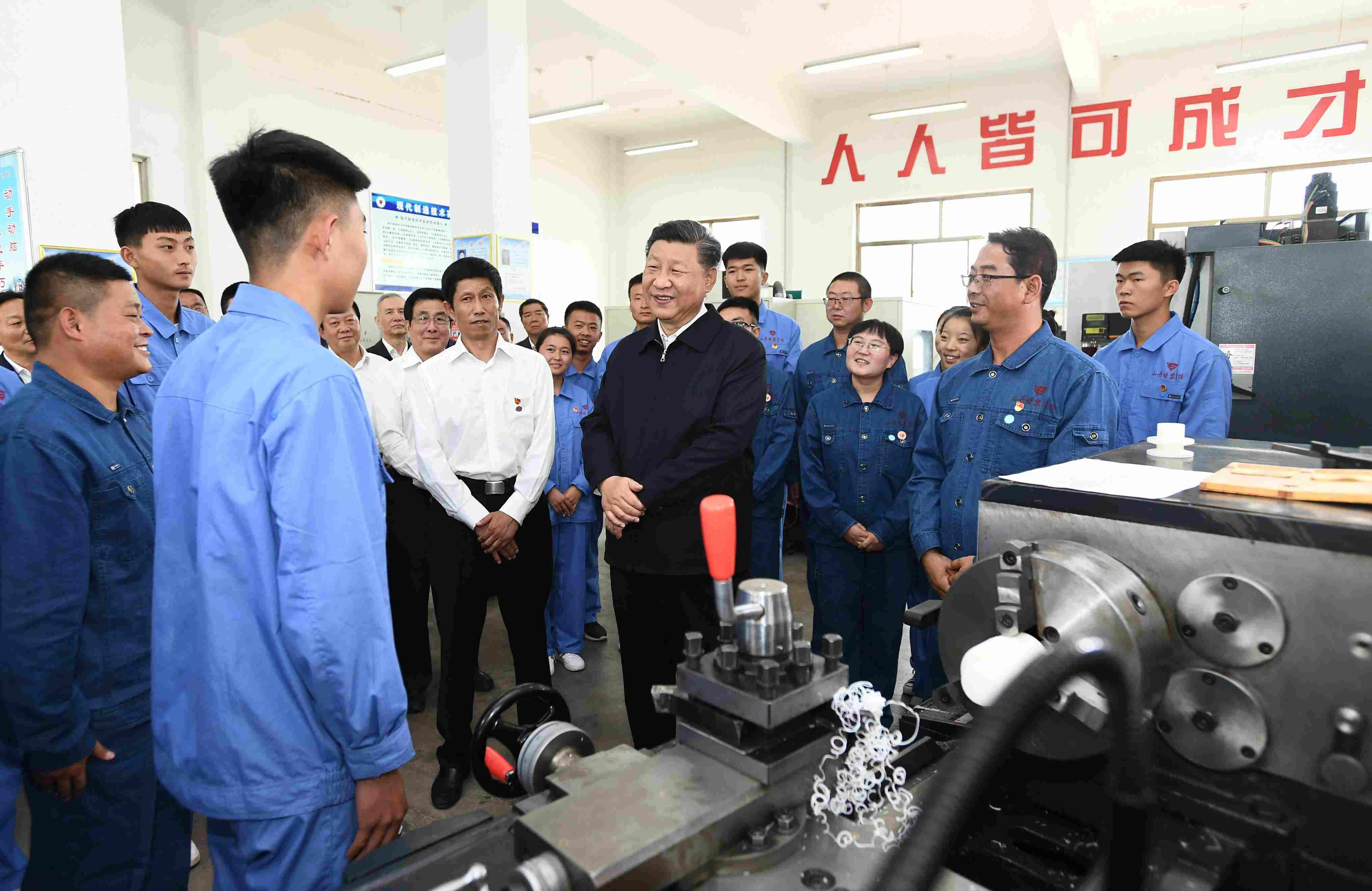 2019年8月20日，習(xí)近平在甘肅省張掖市山丹培黎學(xué)校現(xiàn)代制造技術(shù)實訓(xùn)室，觀看職業(yè)技能實訓(xùn)，同師生親切交流。