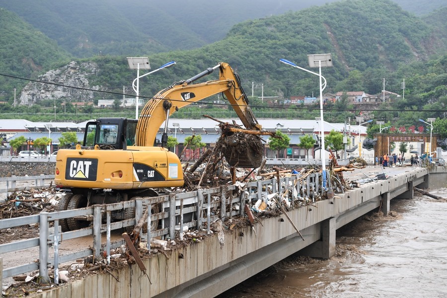 8月1日，在北京市門頭溝區(qū)水峪嘴村村口，一臺挖掘機在清理阻斷橋梁交通的雜物。目前該條道路已經(jīng)疏通完成。新華社記者 鞠煥宗 攝