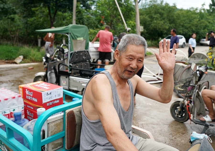 8月5日，從安置點回來的北京市房山區(qū)青龍湖鎮(zhèn)口頭村村民高大爺領(lǐng)到生活物資準備回家。新華社記者 張晨霖 攝