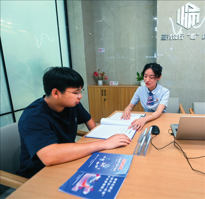 在杭州市臨安區(qū)政務服務中心的“為企服務中心”，黨員志愿者（右）解答企業(yè)主的疑問（2023年7月7日攝）。徐昱攝/本刊