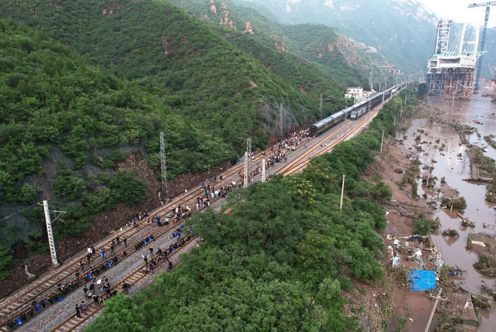 8月2日，受困列車旅客在救援人員幫助下徒步趕往轉(zhuǎn)運(yùn)客車（無人機(jī)照片）。新華社記者 張晨霖 攝
