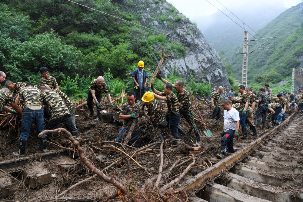 8月1日，在北京市門頭溝區(qū)水峪嘴村附近一段被阻斷的鐵路線上，中鐵六局工作人員在清理軌道上的雜物，全力恢復(fù)交通。新華社記者 鞠煥宗 攝