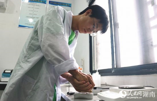 吳健筆在獼猴桃科技小院實(shí)驗(yàn)室測(cè)量水果糖分。 人民網(wǎng)記者 劉賓攝