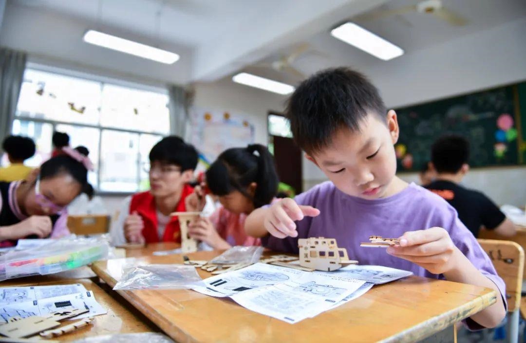 △今年7月，在浙江余姚市舜北小學(xué)暑托班內(nèi)，孩子們制作太陽能科學(xué)實驗裝置。