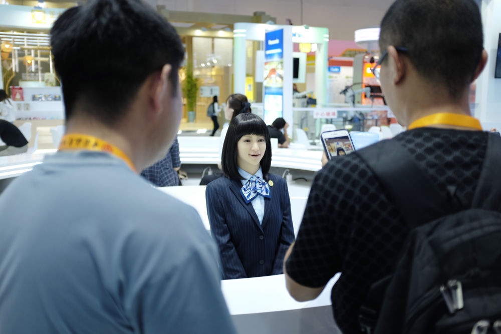 9月1日，媒體記者在國家會議中心與服務(wù)機(jī)器人互動。新華社記者 劉夢琪 攝