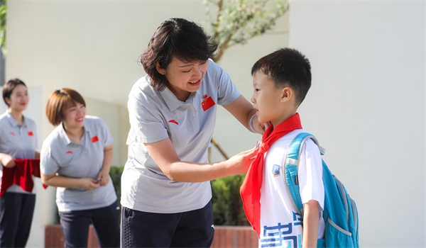 8月30日，雄安史家胡同小學(xué)學(xué)生體驗(yàn)學(xué)校生活。老師為學(xué)生佩戴校徽。