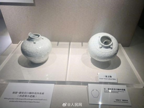 福建德化窯白釉印花四系罐（左）。人民網(wǎng)記者 李娜攝