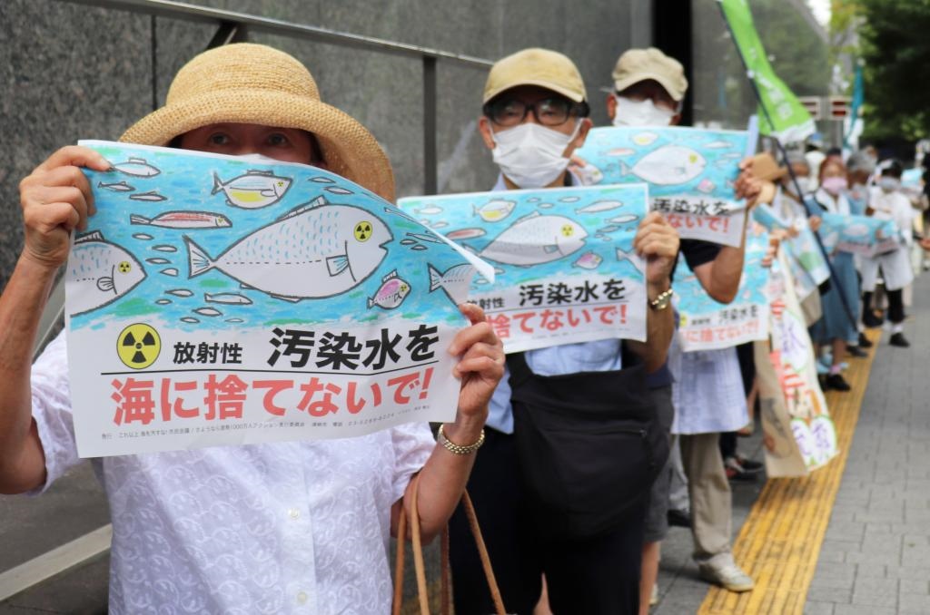 8月24日，日本民眾手持“不要將污染水扔進(jìn)大?！钡葮?biāo)語在東京電力公司總部前集會(huì)，抗議日本政府和東電公司無視民意啟動(dòng)核污染水排海。新華社記者楊光攝