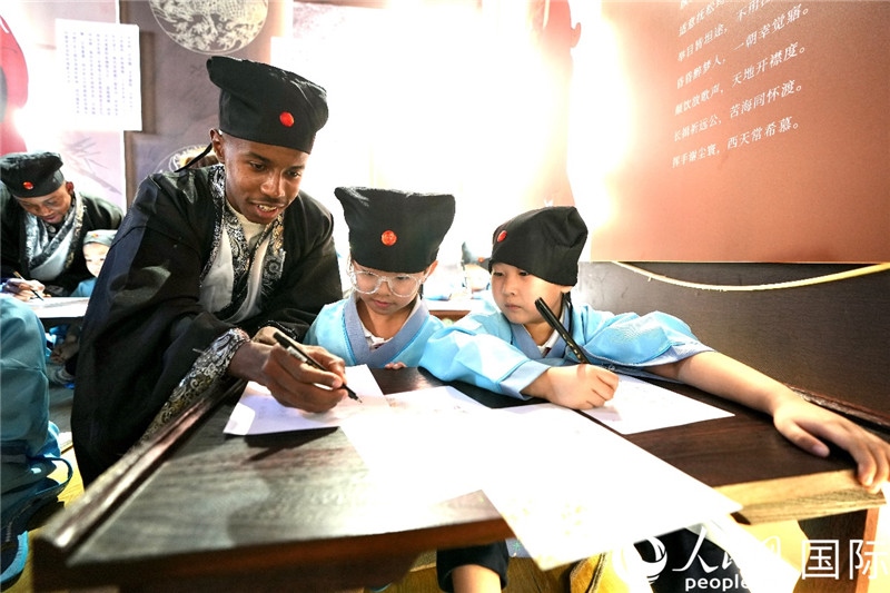 圖為選手與同學(xué)們一起寫(xiě)書(shū)法。人民網(wǎng) 盧鵬宇攝