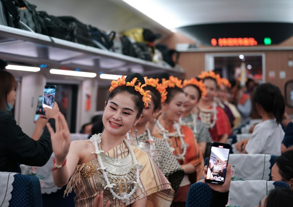 2023年4月13日，老撾工作人員在中老鐵路上開行的D887次國(guó)際旅客列車上表演。新華社記者 邢廣利 攝