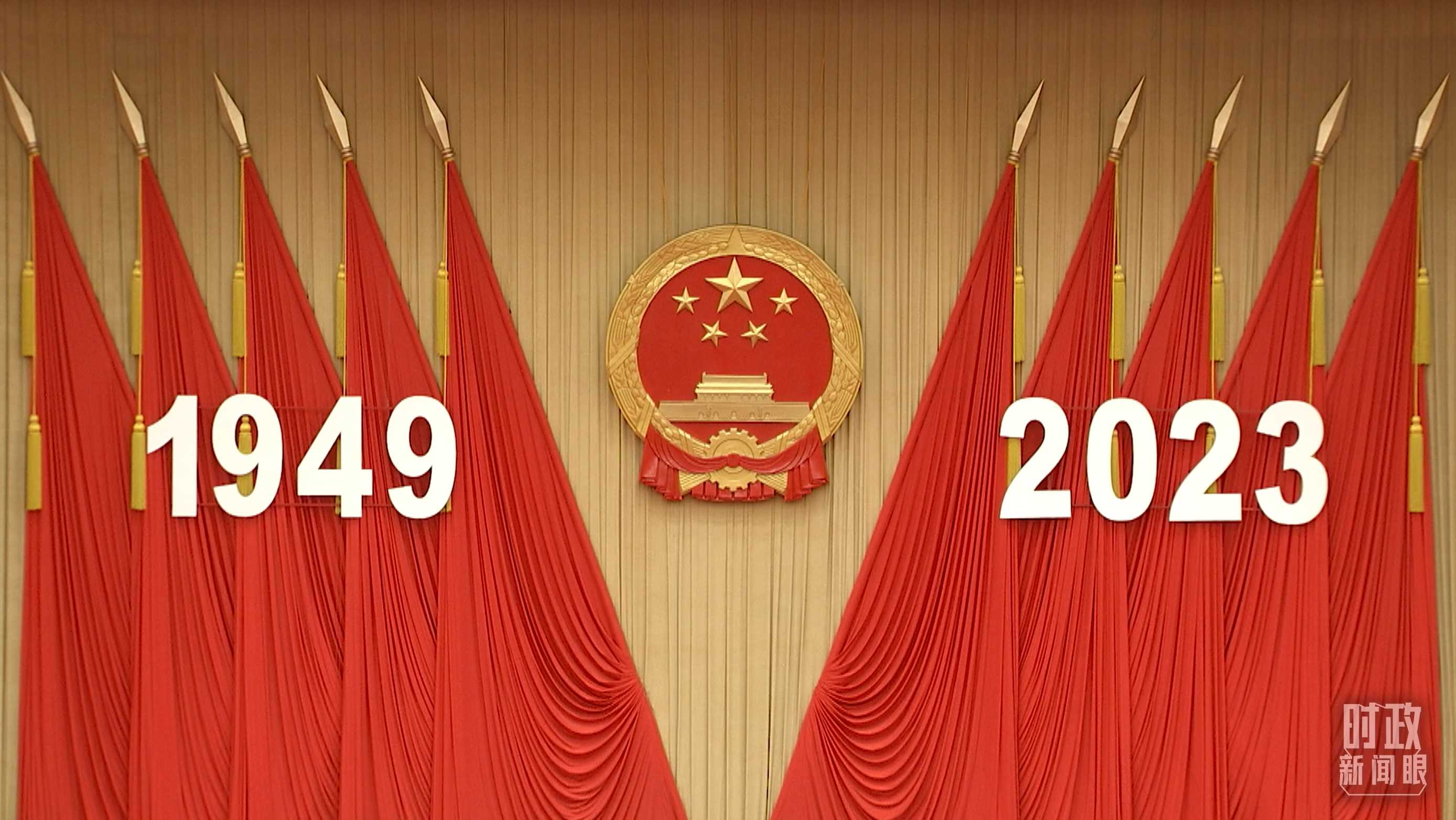 △人民大會堂宴會廳內(nèi)，主席臺上方高懸著莊嚴(yán)的國徽，“1949－2023”大字年號在鮮艷的紅旗映襯下格外醒目。