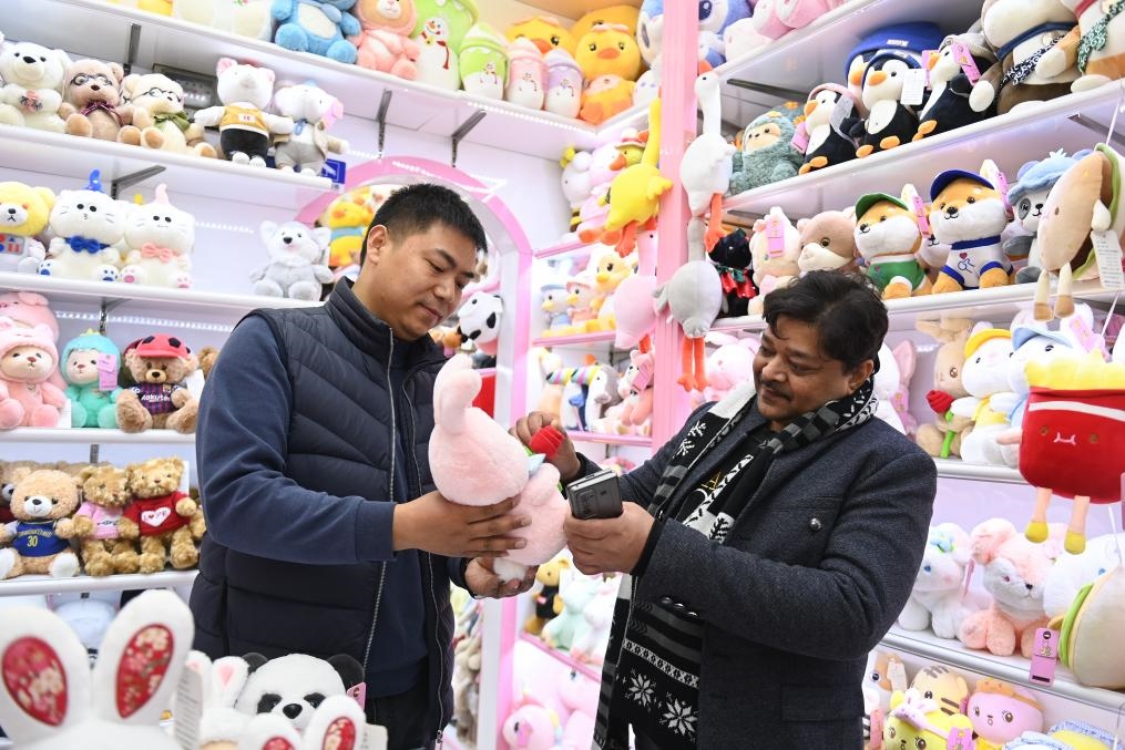 2023年2月2日，來(lái)自印度的客商（右）在義烏國(guó)際商貿(mào)城的一家玩具店鋪內(nèi)選購(gòu)商品。新華社記者 黃宗治 攝