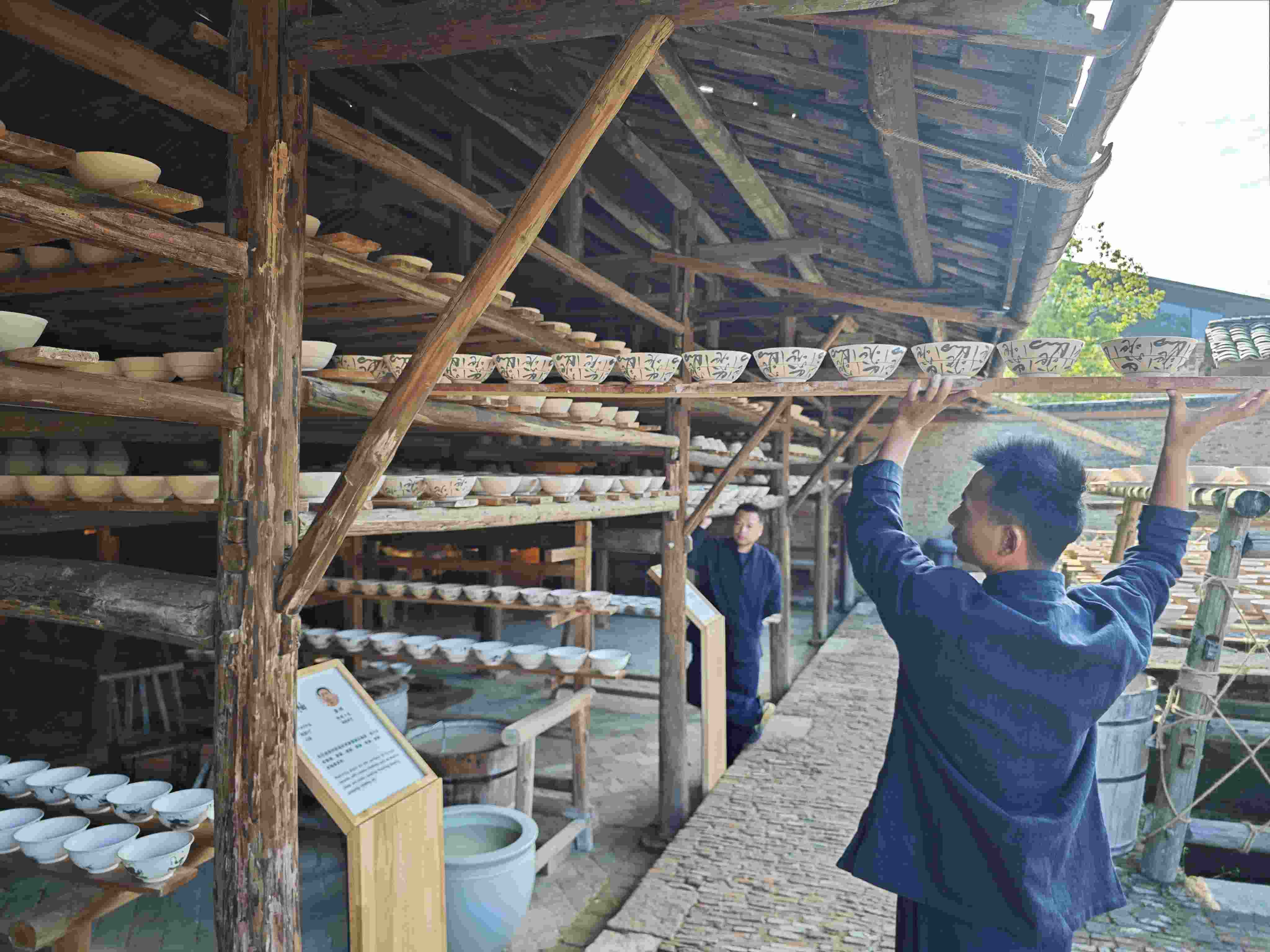 △陶陽里歷史文化街區(qū)里，工匠將陶瓷工藝品放到架上晾干。（總臺(tái)央視記者彭漢明拍攝）