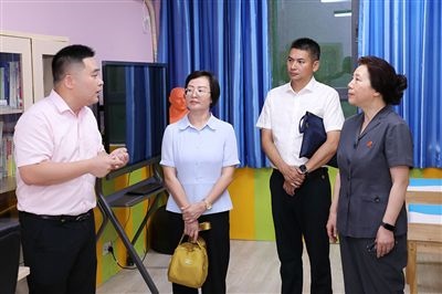 圖③：“小公民法律課堂”開講前，全國人大代表殷其龍（右二）、重慶市人大代表李自玲（左二）聽取楊家坪中學負責人關于未成年人思想教育工作情況的介紹。