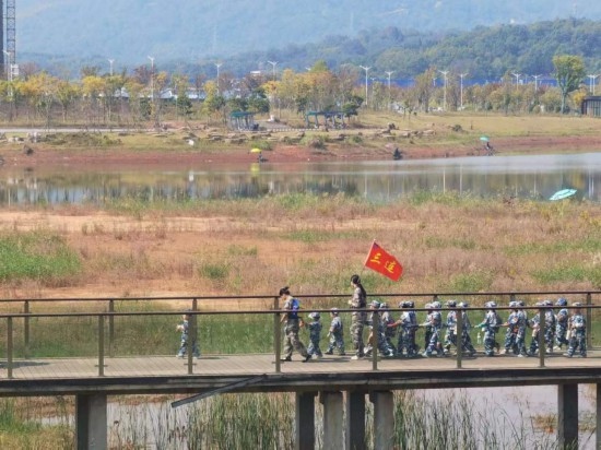 10月24日，秋游的幼兒園小朋友在老師帶領(lǐng)下走在清水塘公園里的木橋上。本報(bào)記者 常雯宜攝