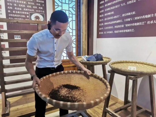 2023“一帶一路”媒體合作論壇聯(lián)合采訪團團員在非遺文化展示館體驗中藥炮制技藝。（本報記者 黃超攝）
