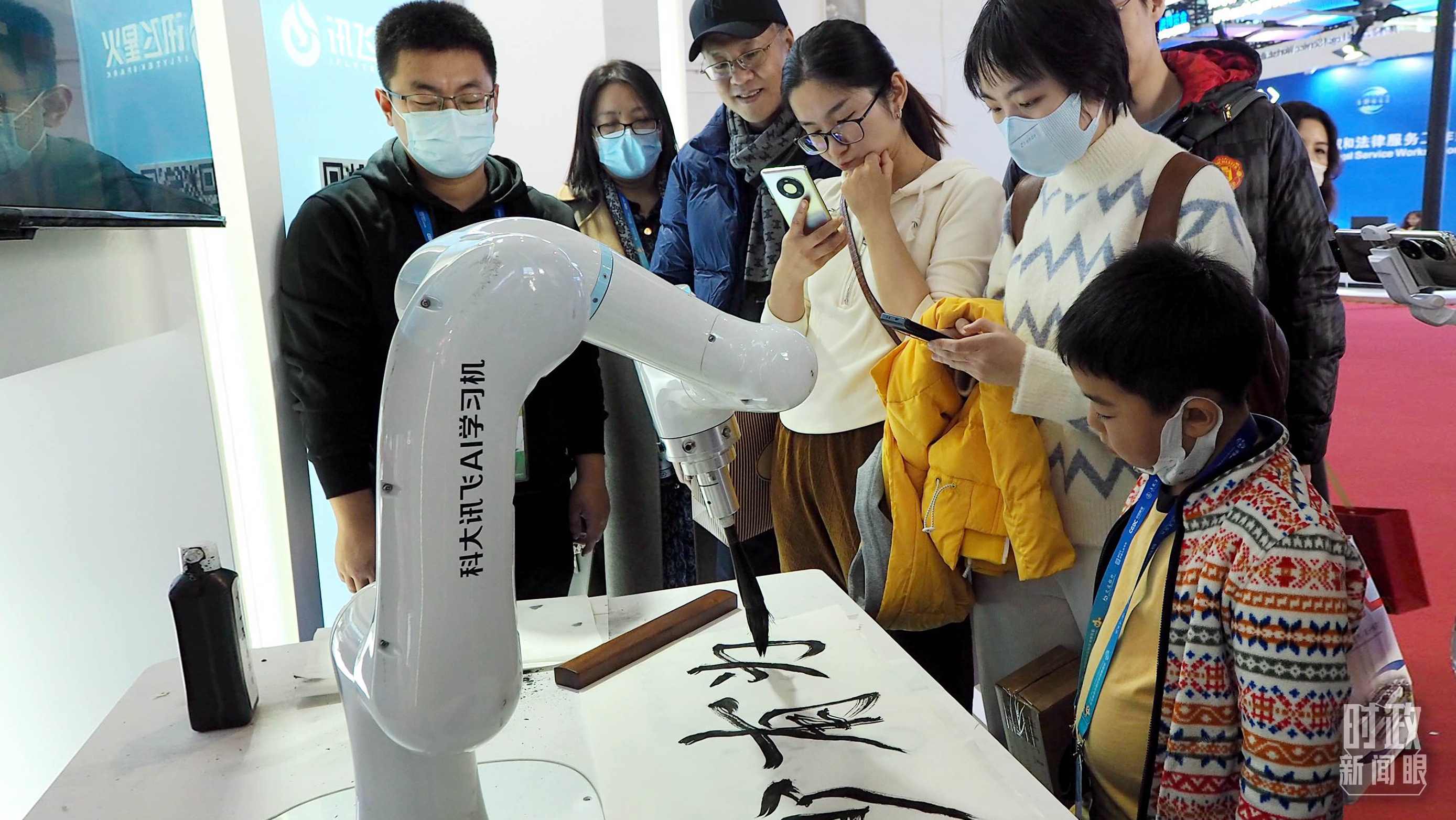 △觀眾在首屆鏈博會上體驗AI書法機器人。