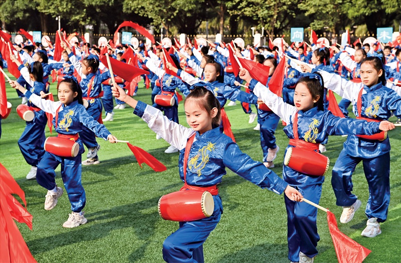 為助推民族地區(qū)基礎(chǔ)教育事業(yè)發(fā)展，廣西重新核定各地中小學(xué)教職工編制，依托全區(qū)編制“周轉(zhuǎn)池”核增事業(yè)編制給各地中小學(xué)，在全面達(dá)到國家標(biāo)準(zhǔn)的基礎(chǔ)上，進(jìn)一步統(tǒng)籌優(yōu)化和動態(tài)調(diào)整各區(qū)域、學(xué)校、學(xué)段間編制資源。圖為2023年11月29日，南寧市濱湖路小學(xué)舉行主題為“逐夢新時(shí)代 健體向未來”的體育文化節(jié)，孩子們正在跳腰鼓舞。 新華社記者 周華/攝