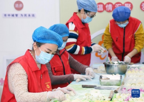 12月16日，在山東省棗莊市市中區(qū)城管藍(lán)職工志愿服務(wù)驛站，愛心志愿者為戶外勞動(dòng)者包水餃。