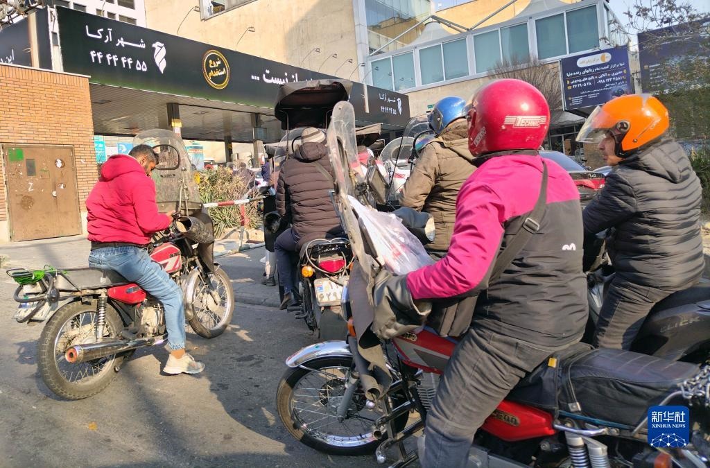 12月18日，摩托車在伊朗首都德黑蘭的一家加油站外等待加油。新華社記者 沙達提 攝