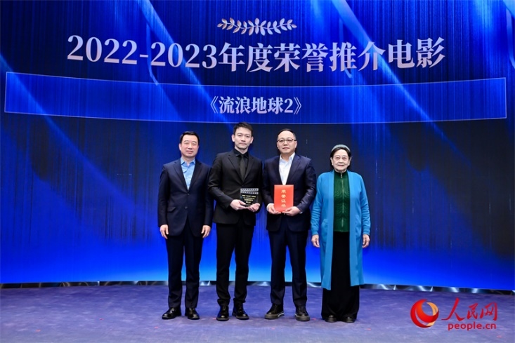 著名電影藝術(shù)家、事業(yè)家王曉棠（右一）和中國文聯(lián)書記處書記張宏（左一）為《流浪地球2》出品人、總監(jiān)制、總制片人傅若清（右二）與導(dǎo)演郭帆（左二）頒發(fā)“2022-2023年度榮譽推介電影”