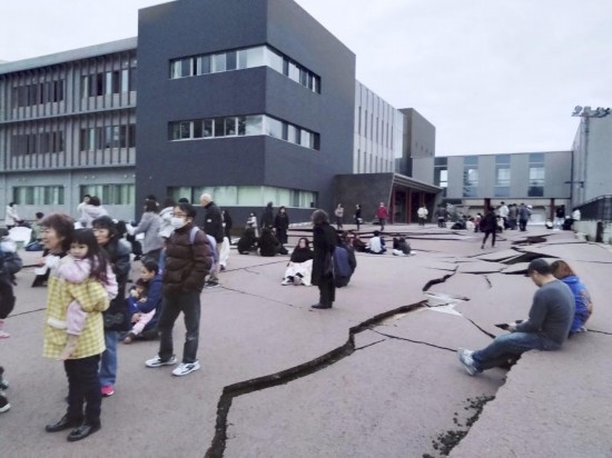  1月1日，在日本石川縣輪島市，人們站在被地震破壞的地面上。新華社/共同社