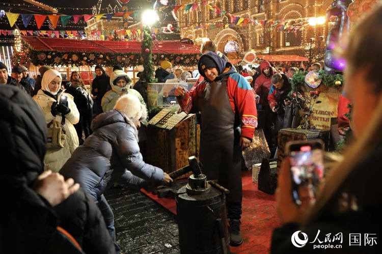 游客在新年集市上體驗(yàn)制作紀(jì)念幣。人民網(wǎng)記者 隋鑫攝