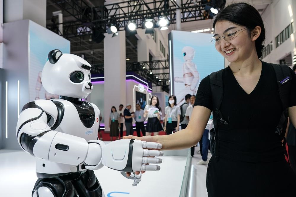 2023年8月16日，一名女士在北京舉辦的2023世界機(jī)器人大會現(xiàn)場與智能機(jī)器人握手。新華社記者彭子洋攝