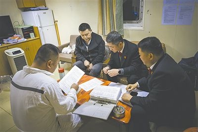 圖②：法官向船長(zhǎng)講解相關(guān)法律規(guī)定，查看船舶資料，并與船方辦理扣押船舶的手續(xù)。